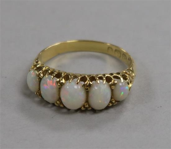 A late Victorian 18ct gold and graduated five stone white opal half hoop ring, size P.